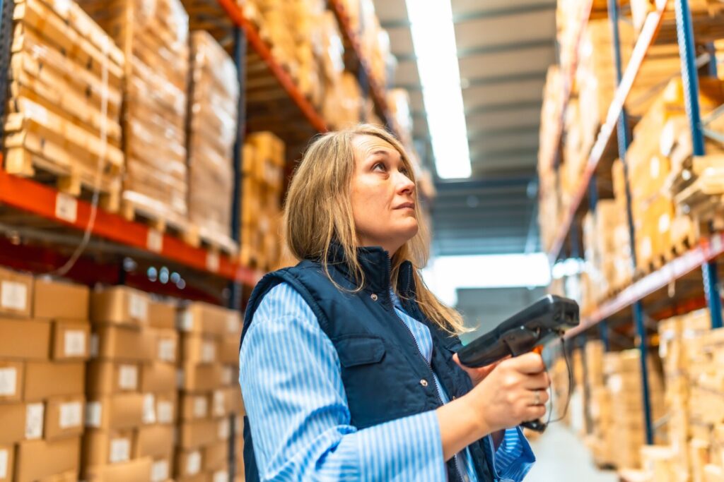 Woman scanning parcels doing inventory while working