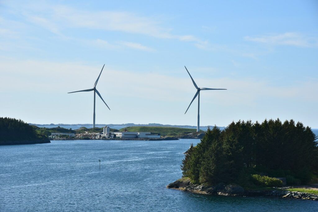 A couple of windmills that are in the water
