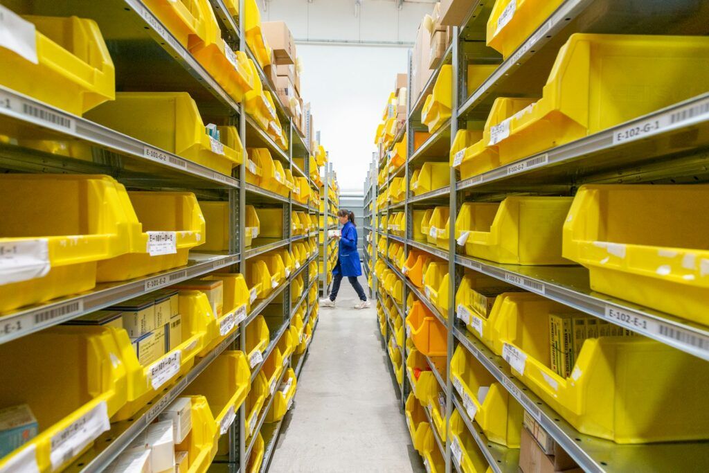 Aisle of shelves with yellow plastic picking crates