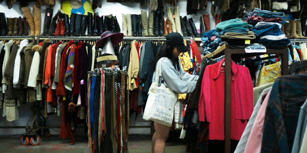 Woman browsing racks of second-hand clothes in a thrift store
